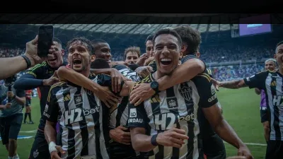 torcedor olhando agenda de jogos do Barcelona no celular enquanto compara Disney+ e ESPN